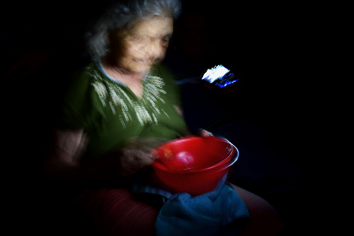 Mi abuela comiendo sopa en plena oscuridad iluminada por la luz de un celular